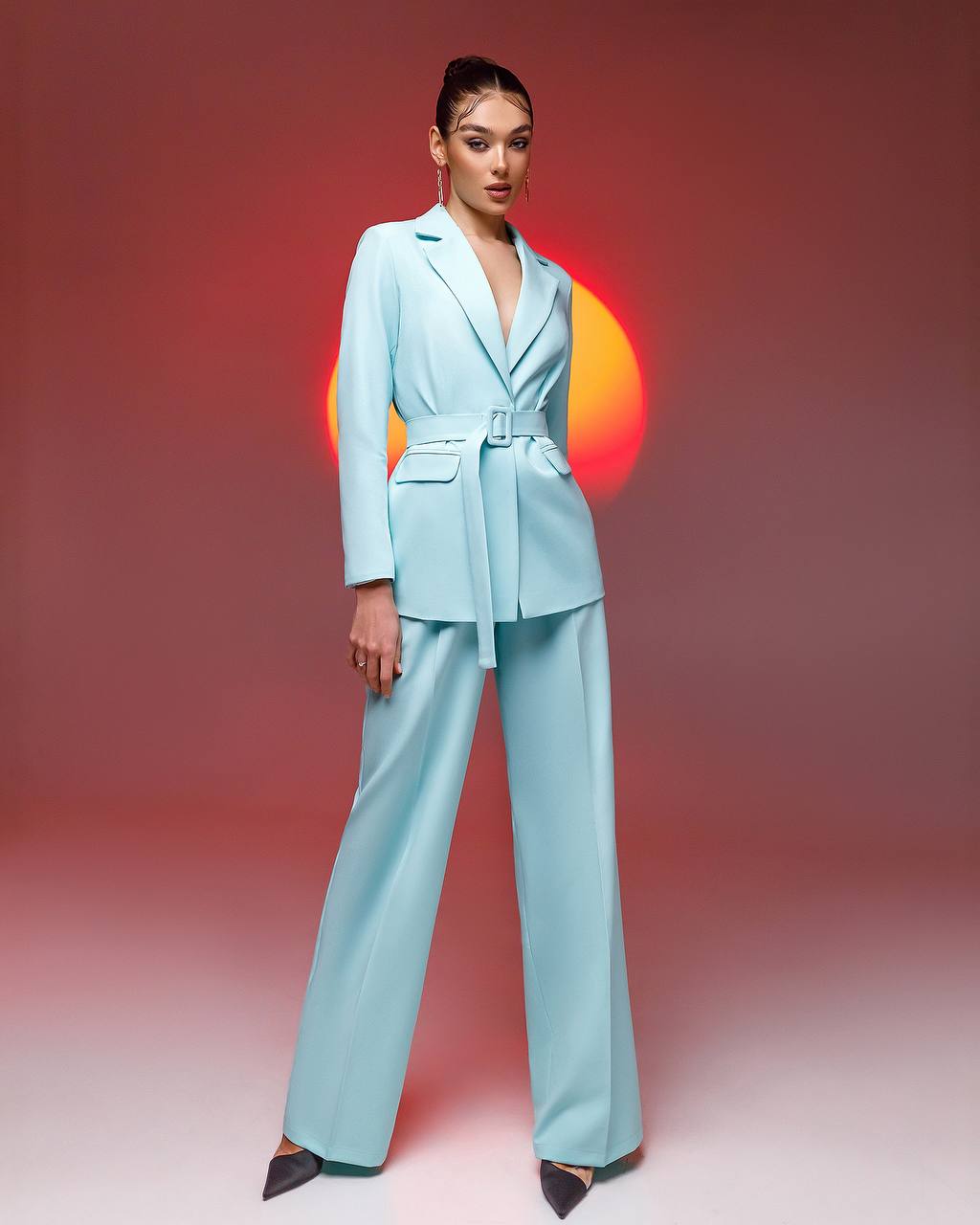 a woman in a light blue suit poses for a picture