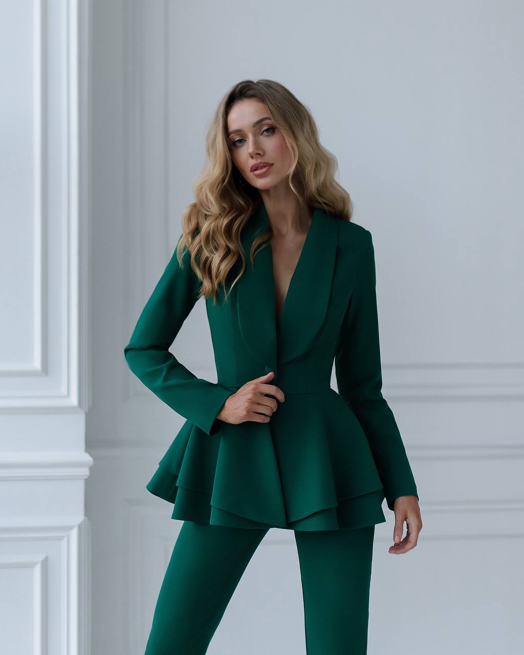 a woman in a green suit posing for the camera