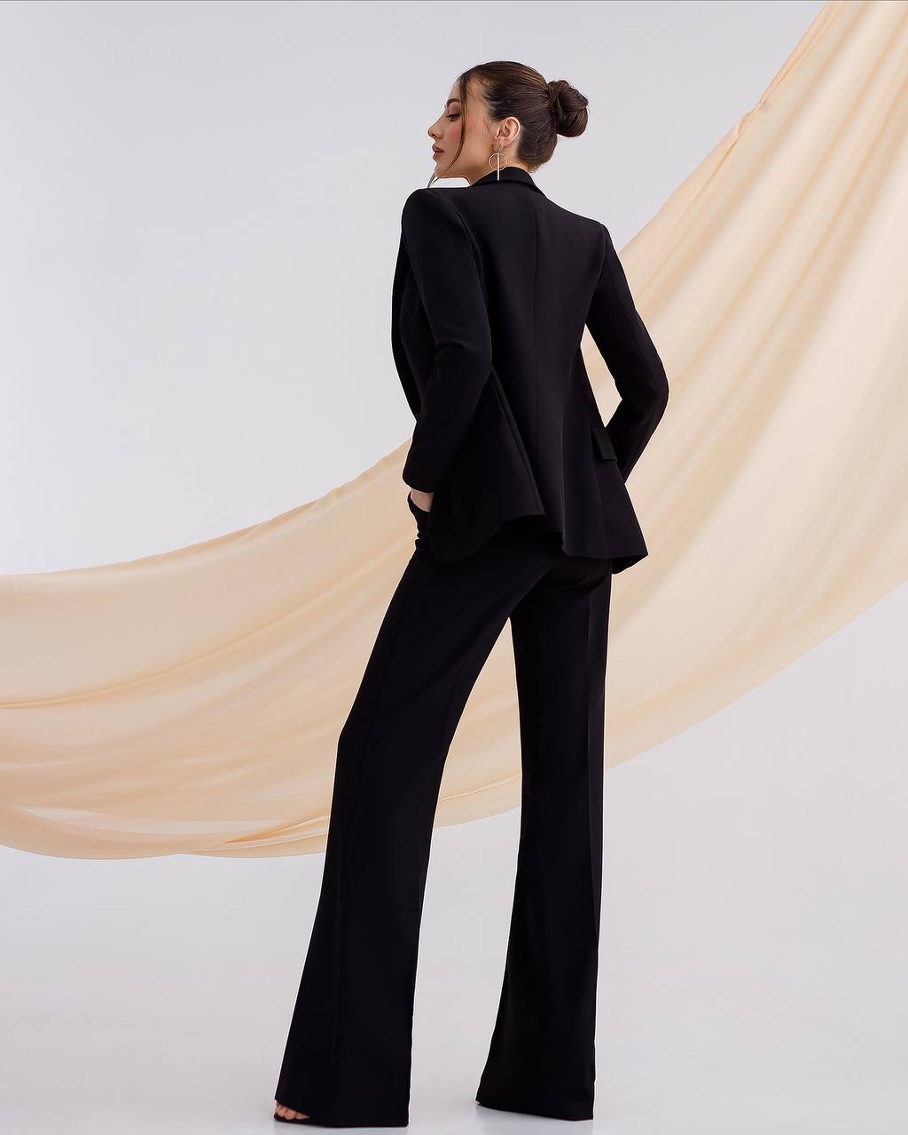 a woman wearing a black suit and pants