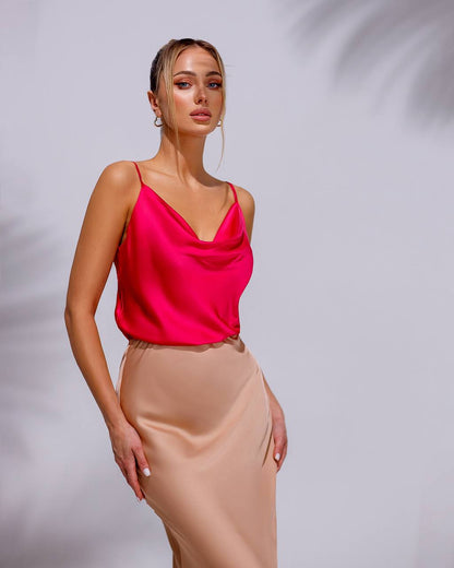 a woman in a pink top and tan skirt