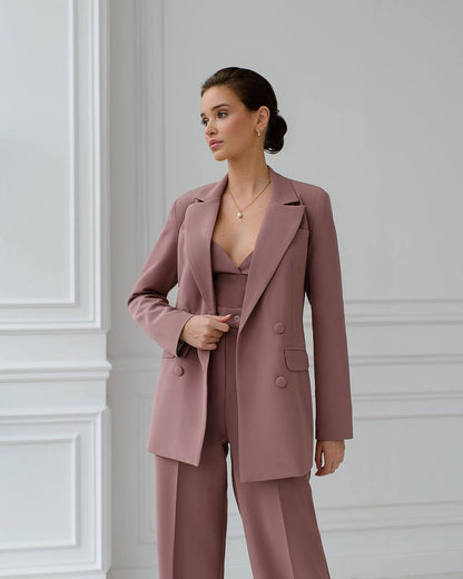 a woman wearing a pink suit and pants