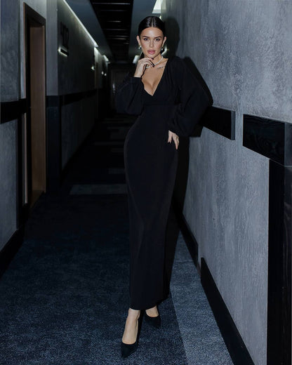 a woman in a black dress standing in a hallway