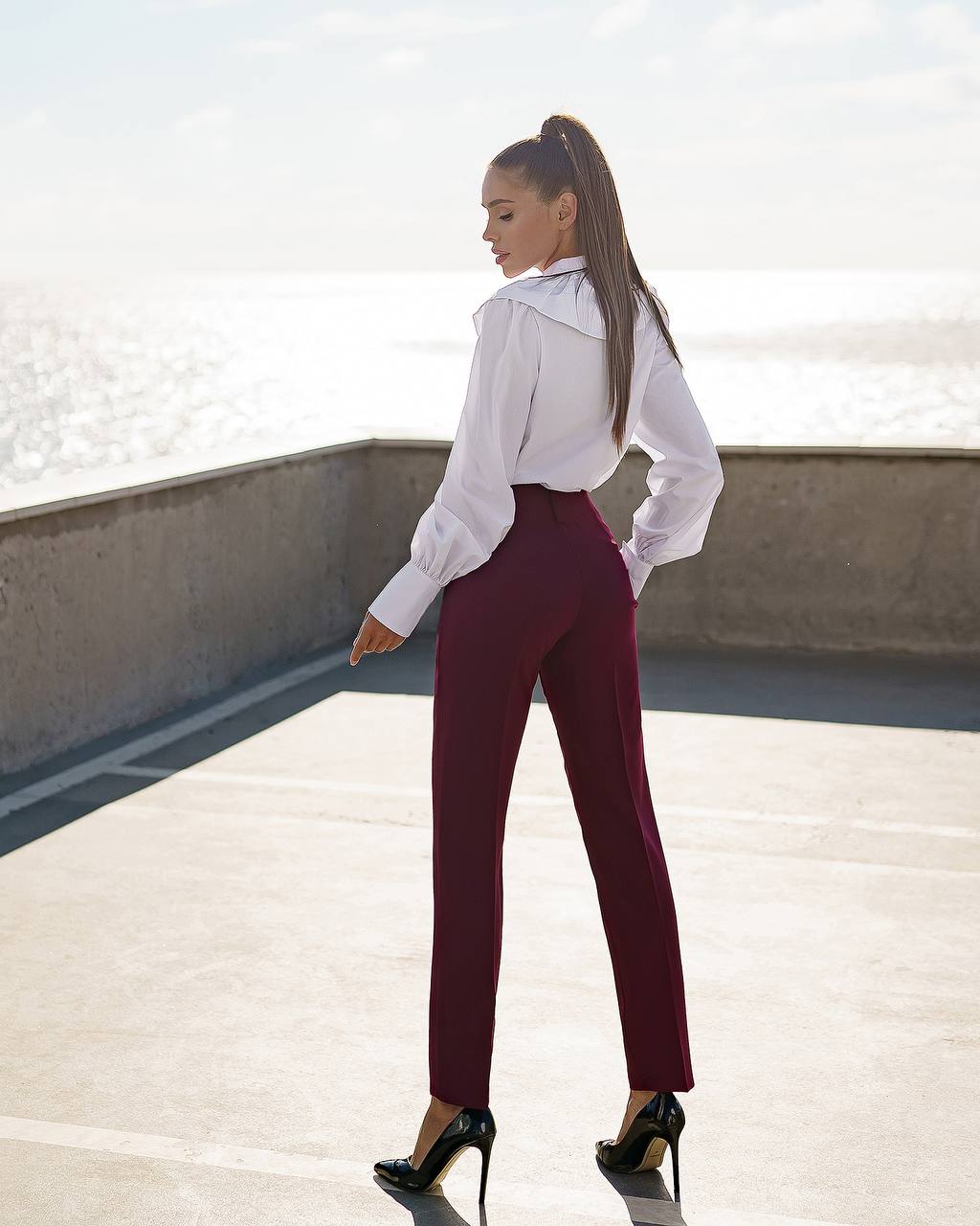 a woman in a white shirt and maroon pants