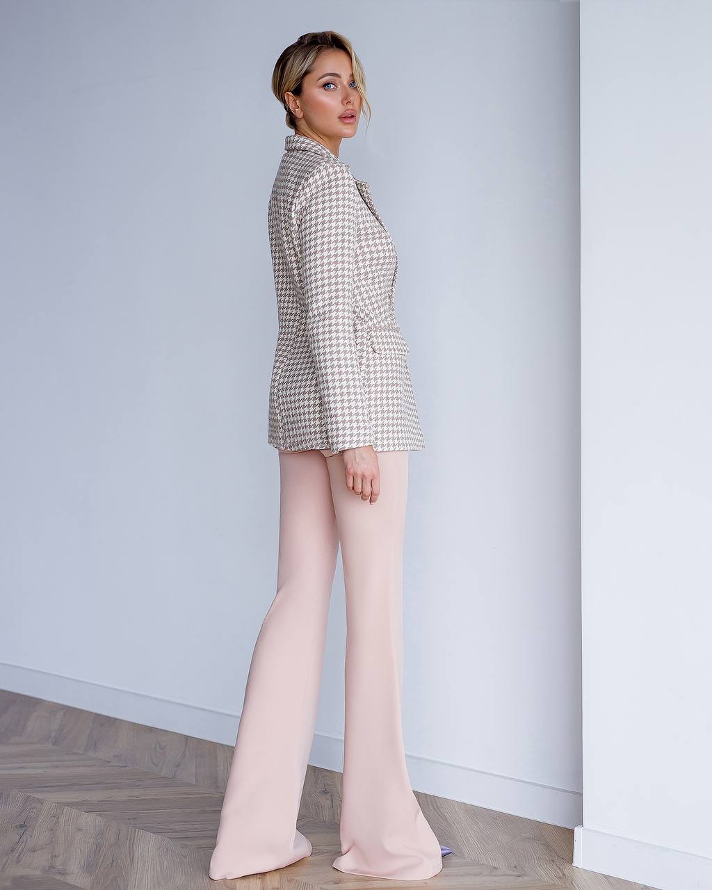 a woman in a white jacket and pink pants