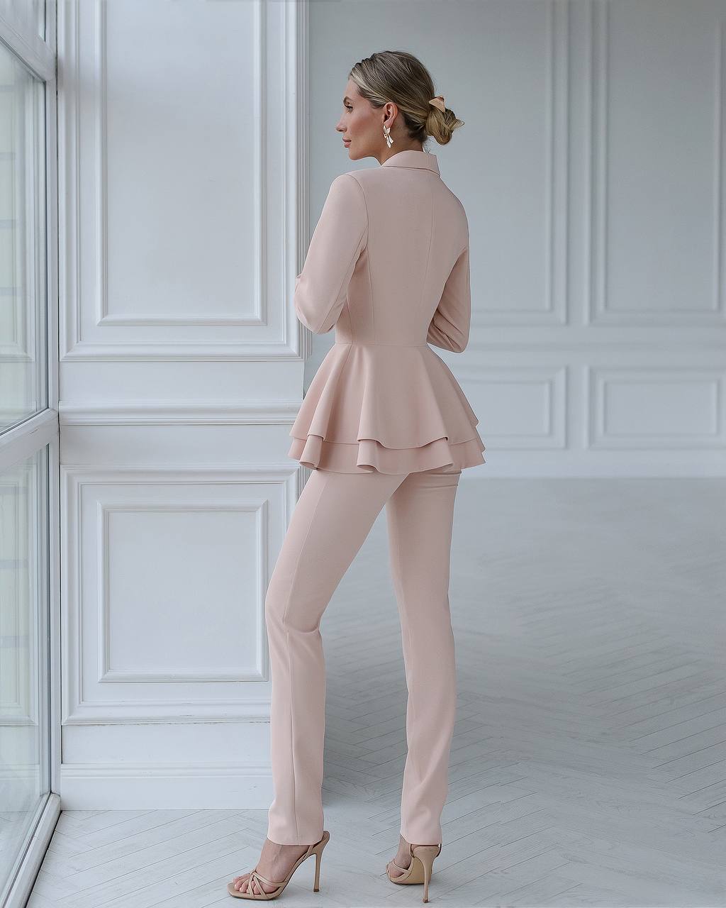 a woman wearing a pink suit and heels