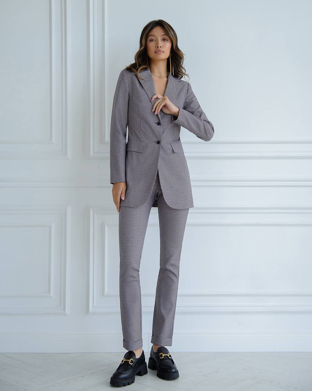 a woman in a gray suit and black shoes