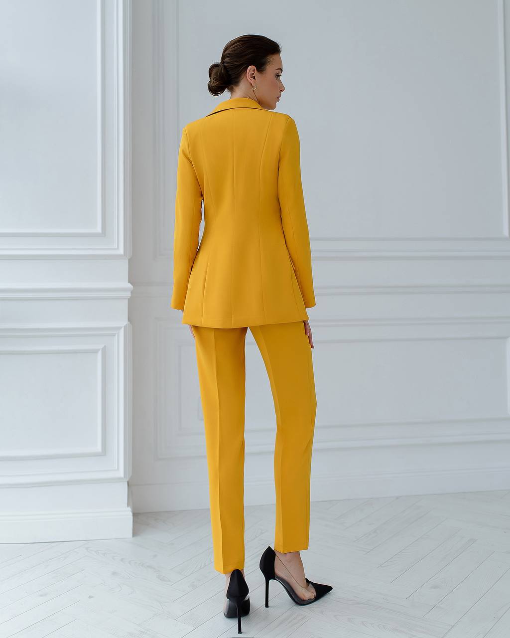 a woman in a yellow suit and high heels