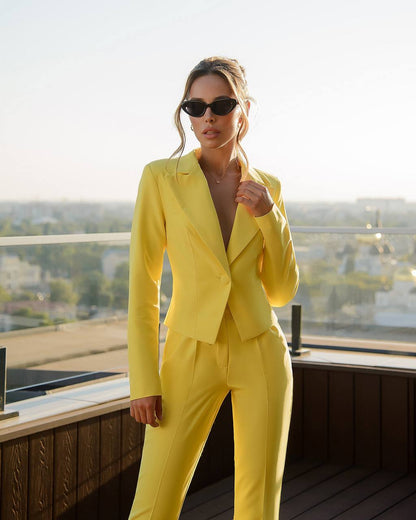 a woman in a yellow suit posing for a picture
