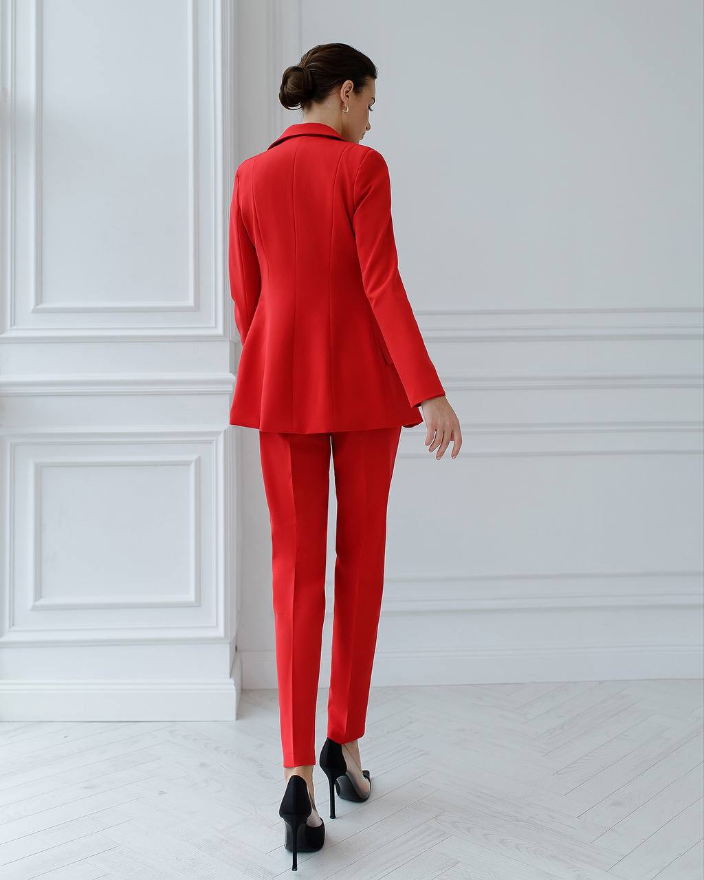 a woman in a red suit and high heels