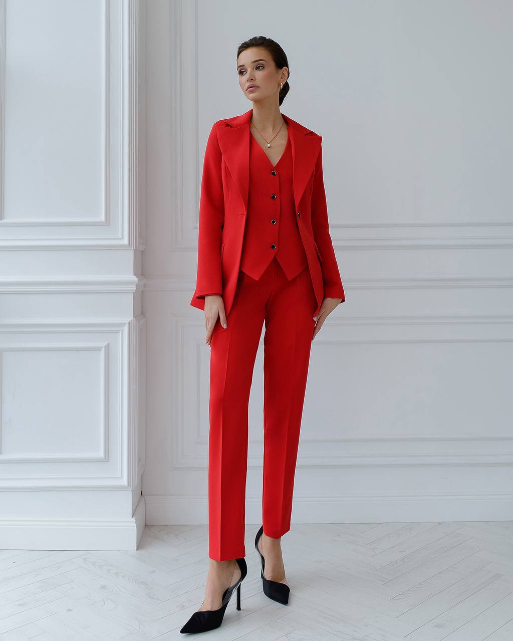a woman wearing a red suit and black shoes
