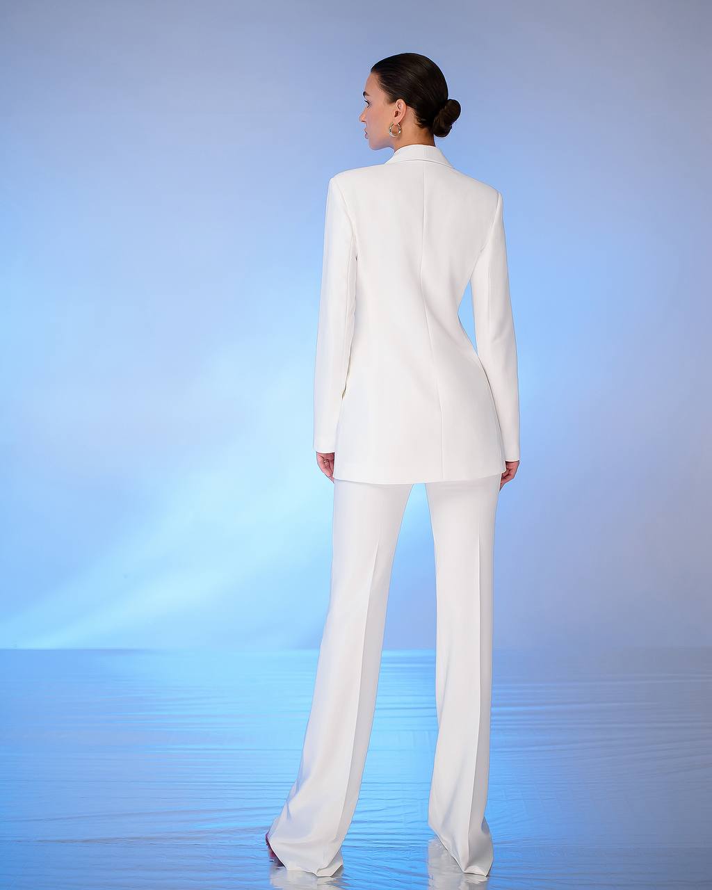 a woman in a white suit standing in water