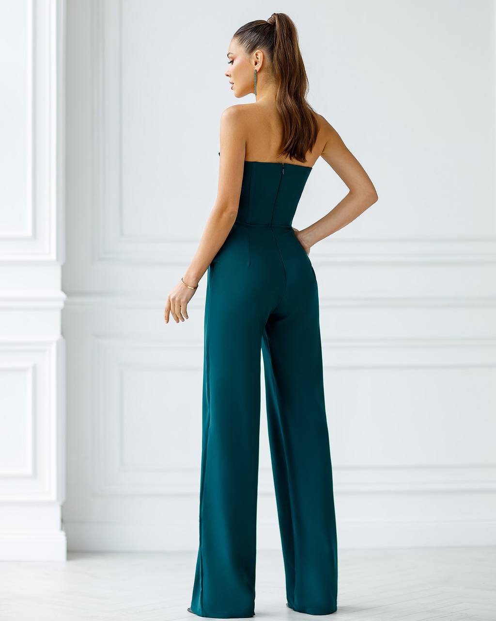 a woman in a green jumpsuit looking back