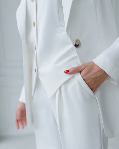 a woman in a white suit with a red manicure