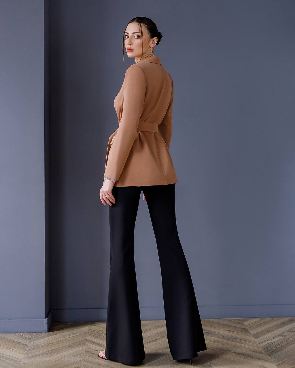 a woman in a brown top and black pants