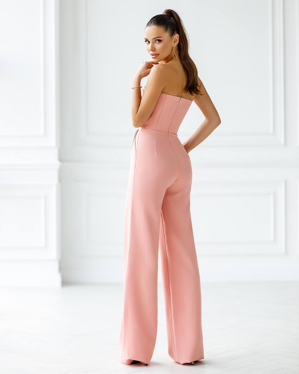 a woman in a pink jumpsuit posing for the camera