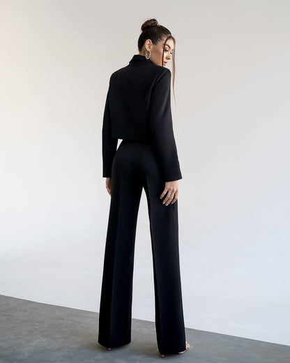 a woman wearing a black suit and high heels