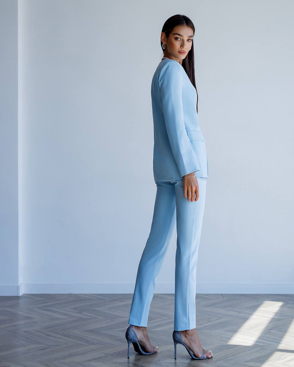 a woman in a blue suit and high heels