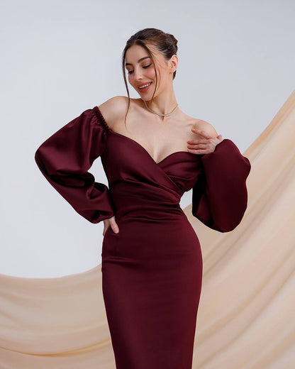 a woman in a burgundy dress posing for a picture
