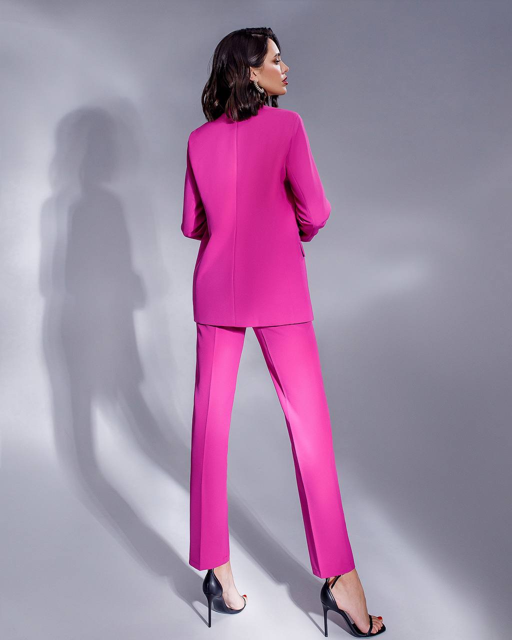 a woman in a pink suit and heels
