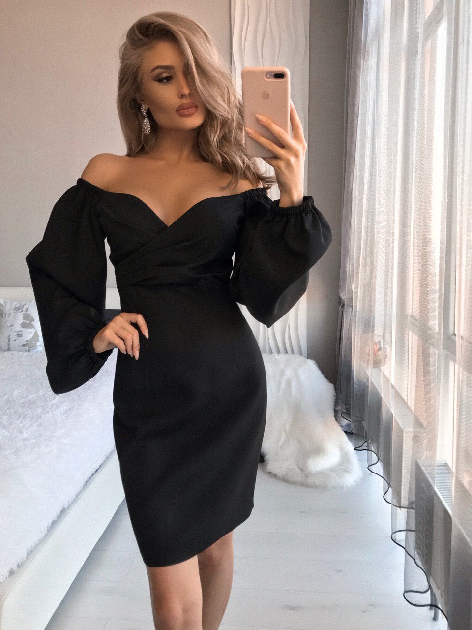 a woman taking a selfie in a black dress