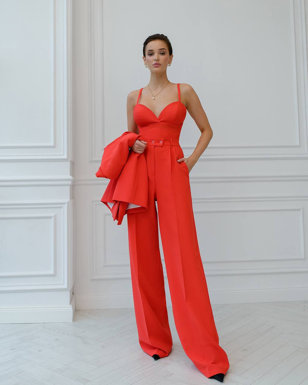 a woman in a red jumpsuit posing for a picture