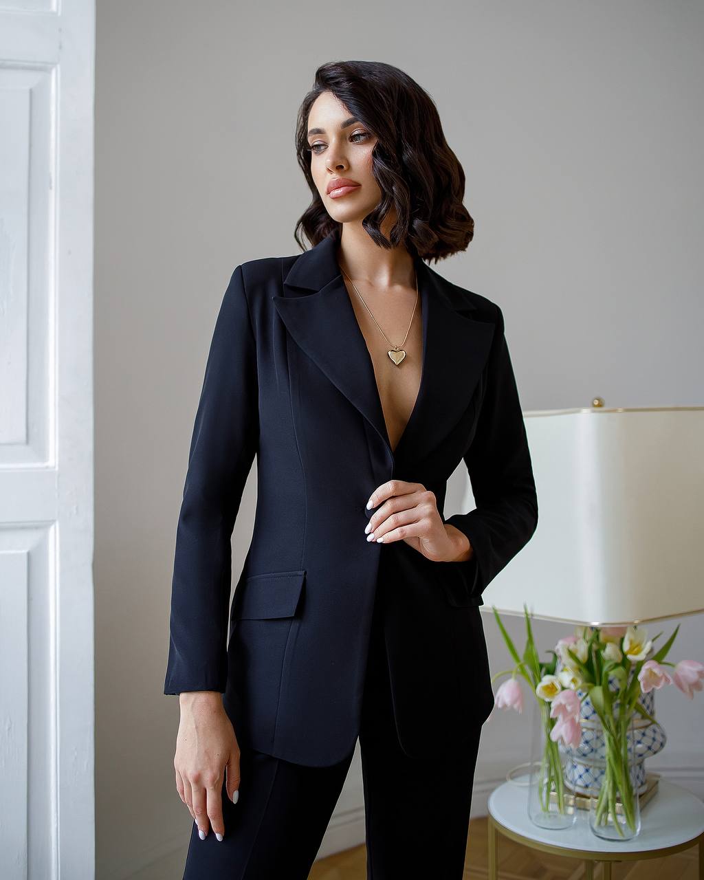 a woman in a black suit posing for a picture