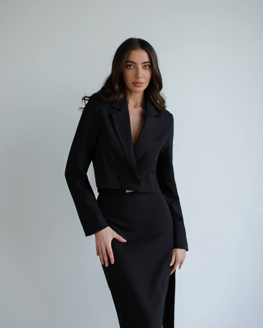 a woman wearing a black suit and heels