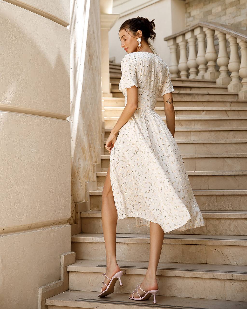a woman in a white dress is standing on some steps