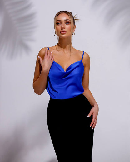 a woman in a blue top and black skirt