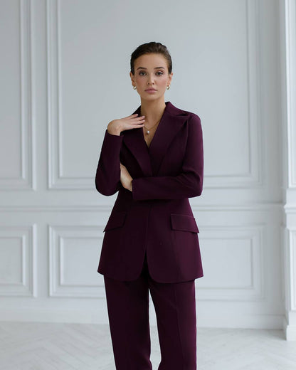 a woman in a purple suit posing for a picture